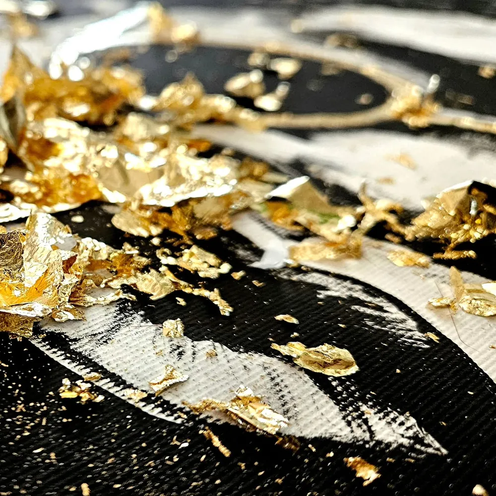 Blattgold-Flocken auf schwarzer Leinwand, Nahaufnahme